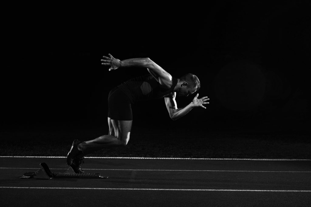 Sprinter leaving starting blocks on the running track. Explosive start.